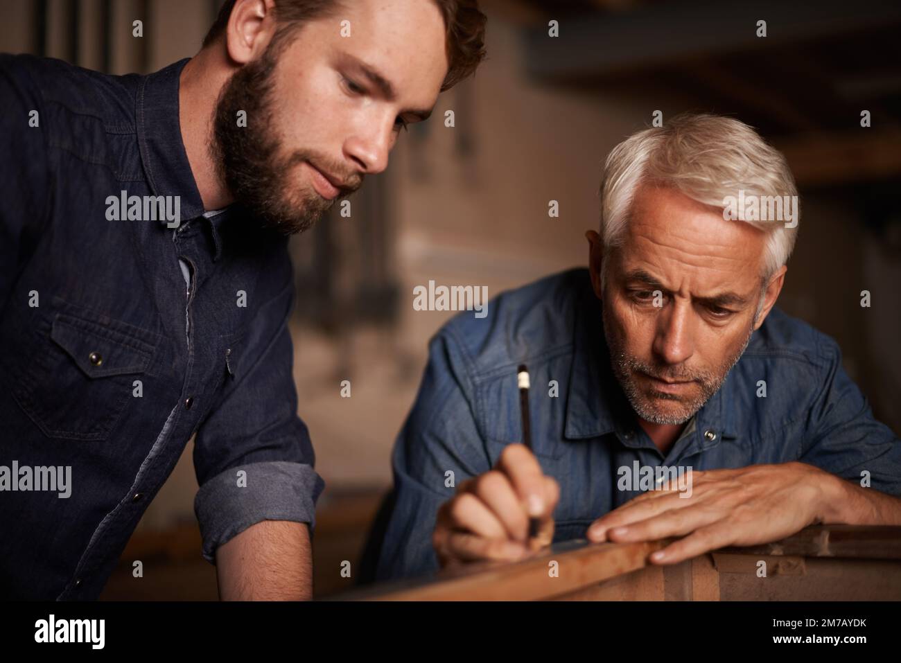 Ich lerne die Tricks des Gewerbes. Ein Vater zeigte seinem Sohn die Tricks des Baugewerbes. Stockfoto