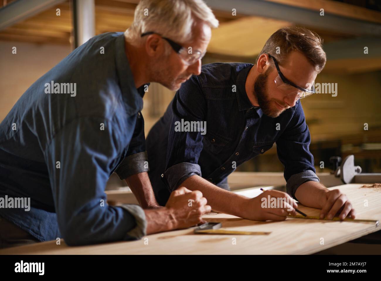 Er hat mein kreatives Gen geerbt. Vater und Sohn arbeiten in einer Werkstatt zusammen. Stockfoto