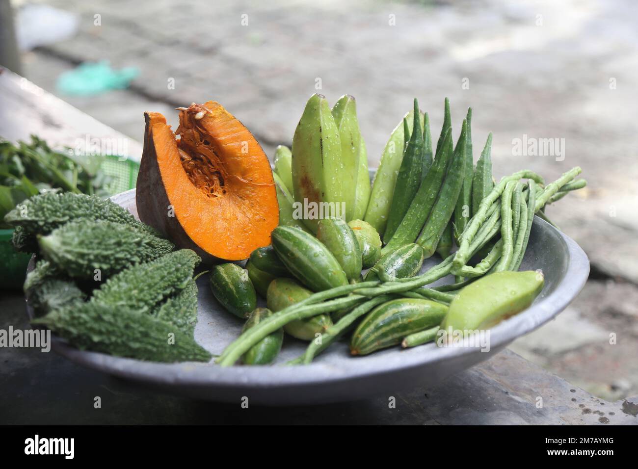 Eine Sammlung von bunten Gemüsesorten, die Kürbis, Bitter Gourd, Grüne Banane und Marienfinger enthalten, ist eine gute Nahrungsquelle für Kinder. Stockfoto