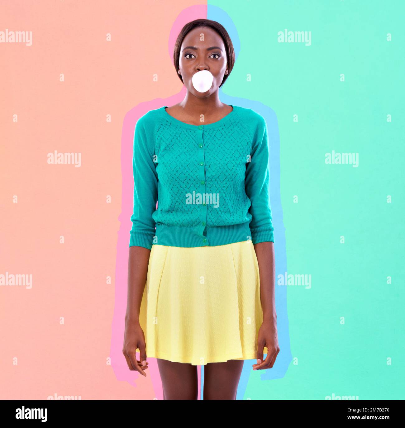 Voller Fruchtgeschmack. Studioaufnahme einer attraktiven jungen Frau, die vor einem bunten Hintergrund eine Kaugummiblase bläst. Stockfoto