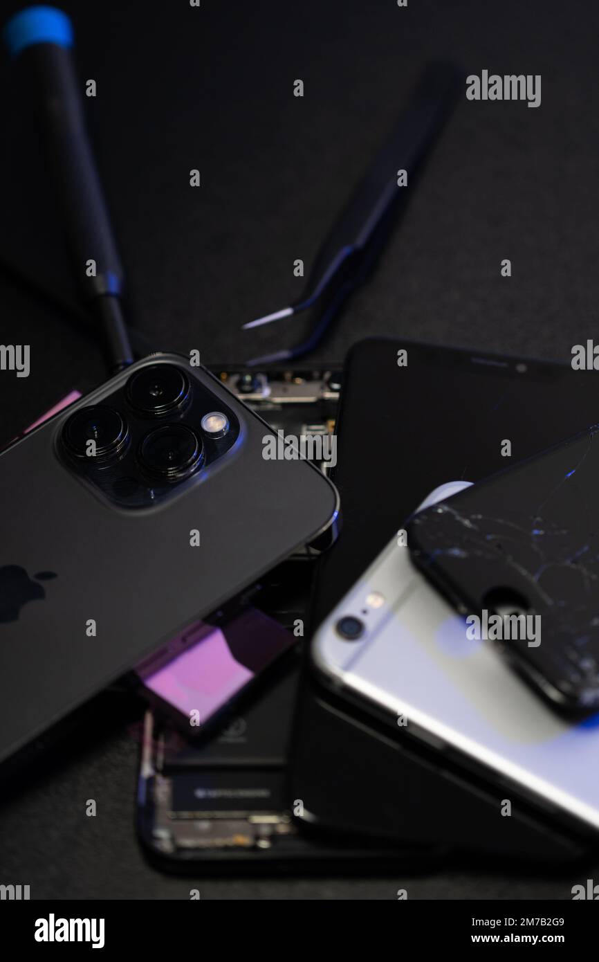 Südtirol, Italien - Januar 7. 2023: Apple iPhone 13 Pro mit iPhone 6 und 10. Verschiedene Smartphones mit Reparaturwerkzeugen. Austausch des defekten Telefonbildschirms Stockfoto