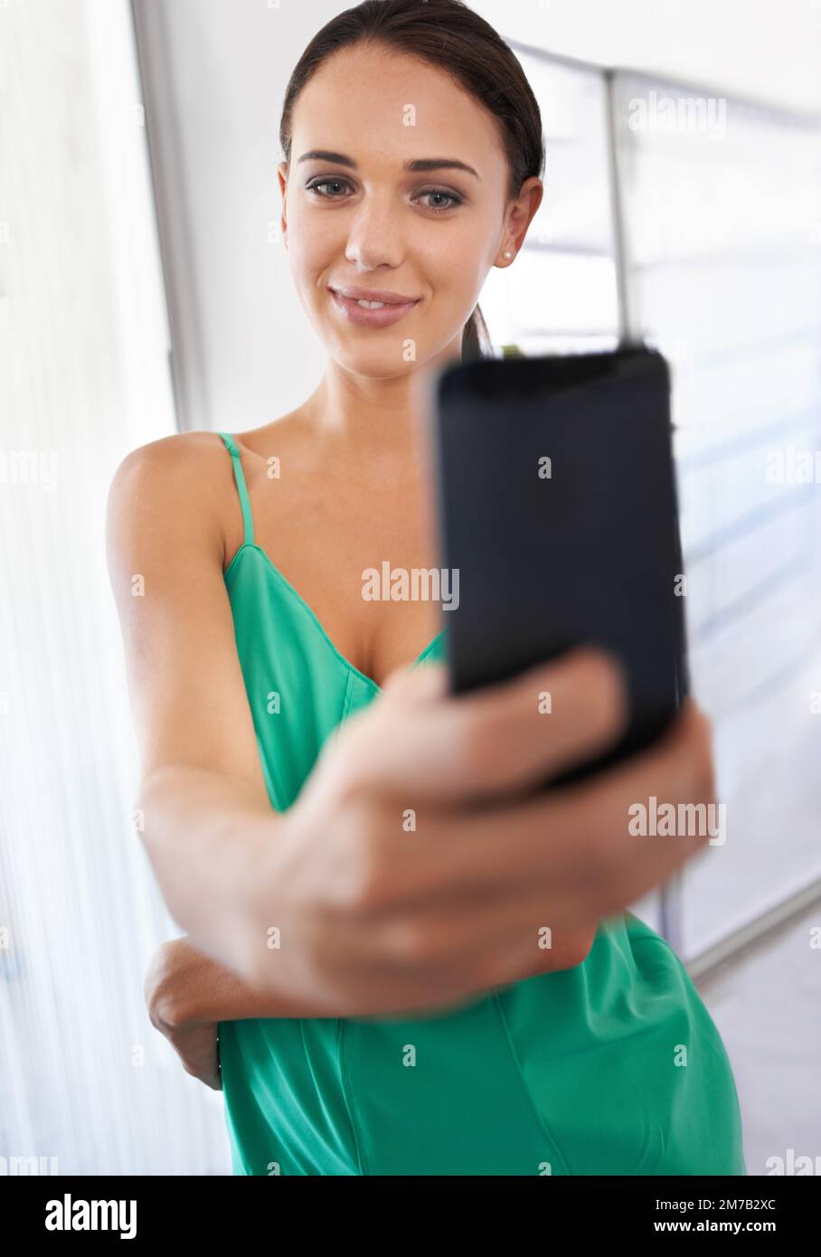 Es ist immer Zeit für ein schnelles Selfie. Hübsche Geschäftsfrau, die ein Foto von einer mobilen Kamera macht. Stockfoto