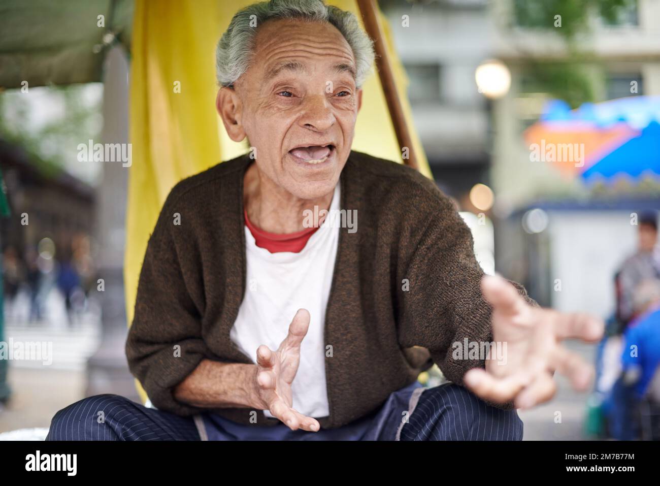 Animiert in seiner Erklärung. Ein alter Mann, der draußen sitzt. Stockfoto