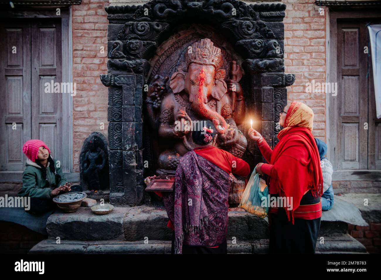 Bhaktapur, Nepal. 9. Januar 2023. Eine ältere Frau bietet eine Butterlampe an eine Statue von Lord Ganesh entlang des Hanumante River in Bhaktapur anlässlich von Shree Swasthani Brata Katha, einem monatelangen Festival, das der Göttin Swasthani und dem Gott Madhav Narayan gewidmet ist. Während des einmonatigen Rituals werden die Geschichten von Göttin Swasthani, Gott Shiva und anderen Göttern erzählt, während die Gläubigen die heilige Schrift vortragen und für das Wohlergehen ihrer Ehepartner beten. Kredit: ZUMA Press, Inc./Alamy Live News Stockfoto