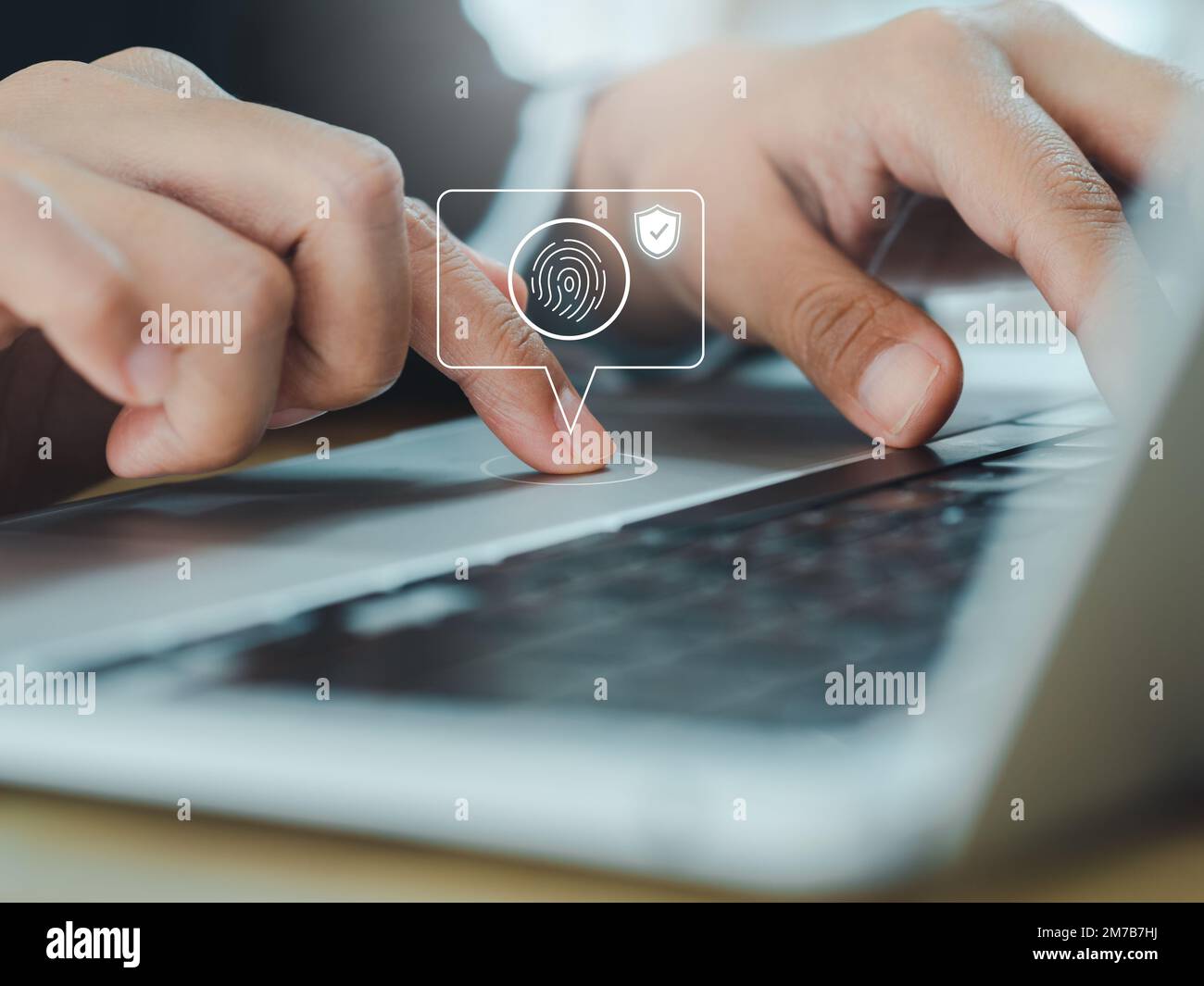 Fingerabdrucksymbol mit Sicherheitsschild in Sprechblase, während Geschäftsleute den Zugriff auf das Touchpad eines Laptops scannen und sich mit Biome anmelden Stockfoto