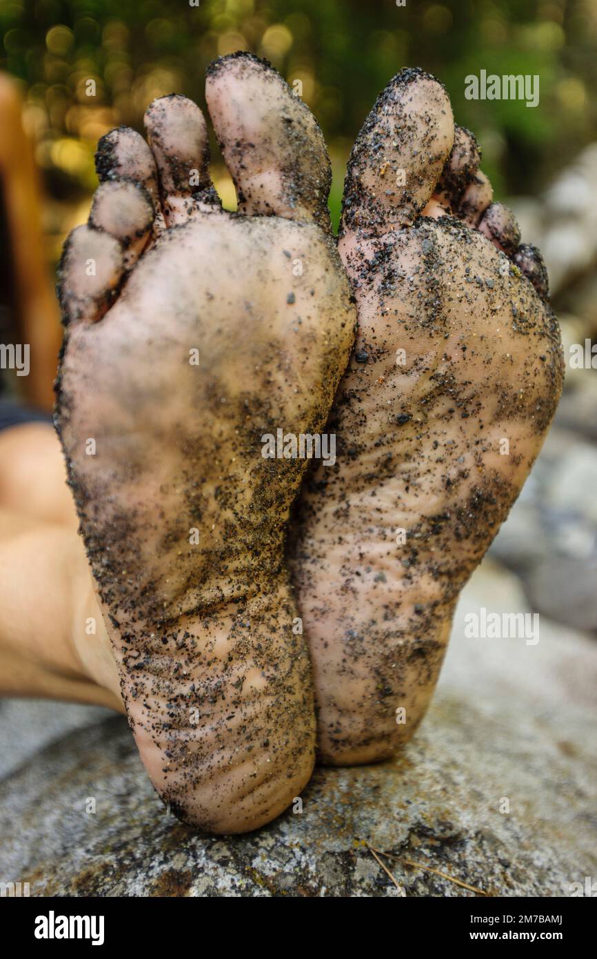 Schmutzige Füße eines Trekkers, der neben dem Cinqueta-Fluss, dem Gistaín-Tal, den Aragonesischen Pyrenäen, Huesca, Spanien ruht. Stockfoto