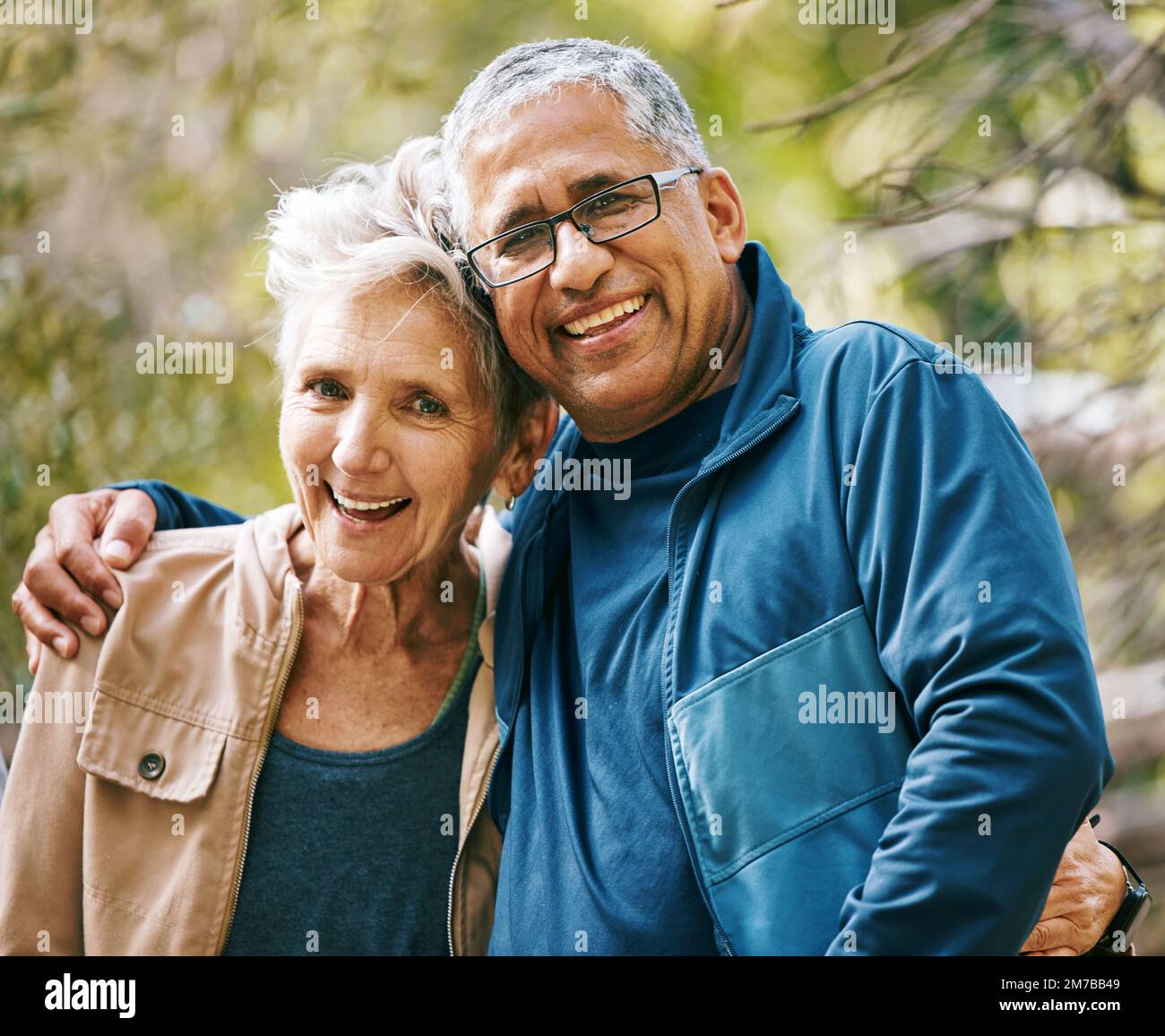 Wandern, Porträt und Romantik mit einem Seniorenpaar, das sich im Sommer im Wald oder im Naturwald umarmt. Spaß, Witze und eine Beziehung zu A Stockfoto