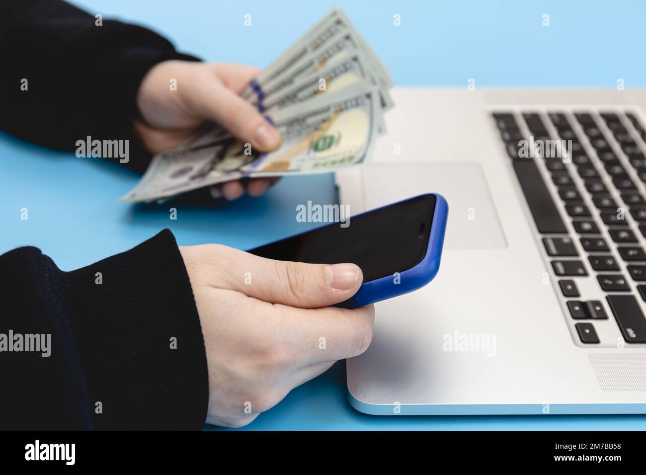Laptop, Smartphone und Geld in männlichen Händen, Nahaufnahme. Stockfoto