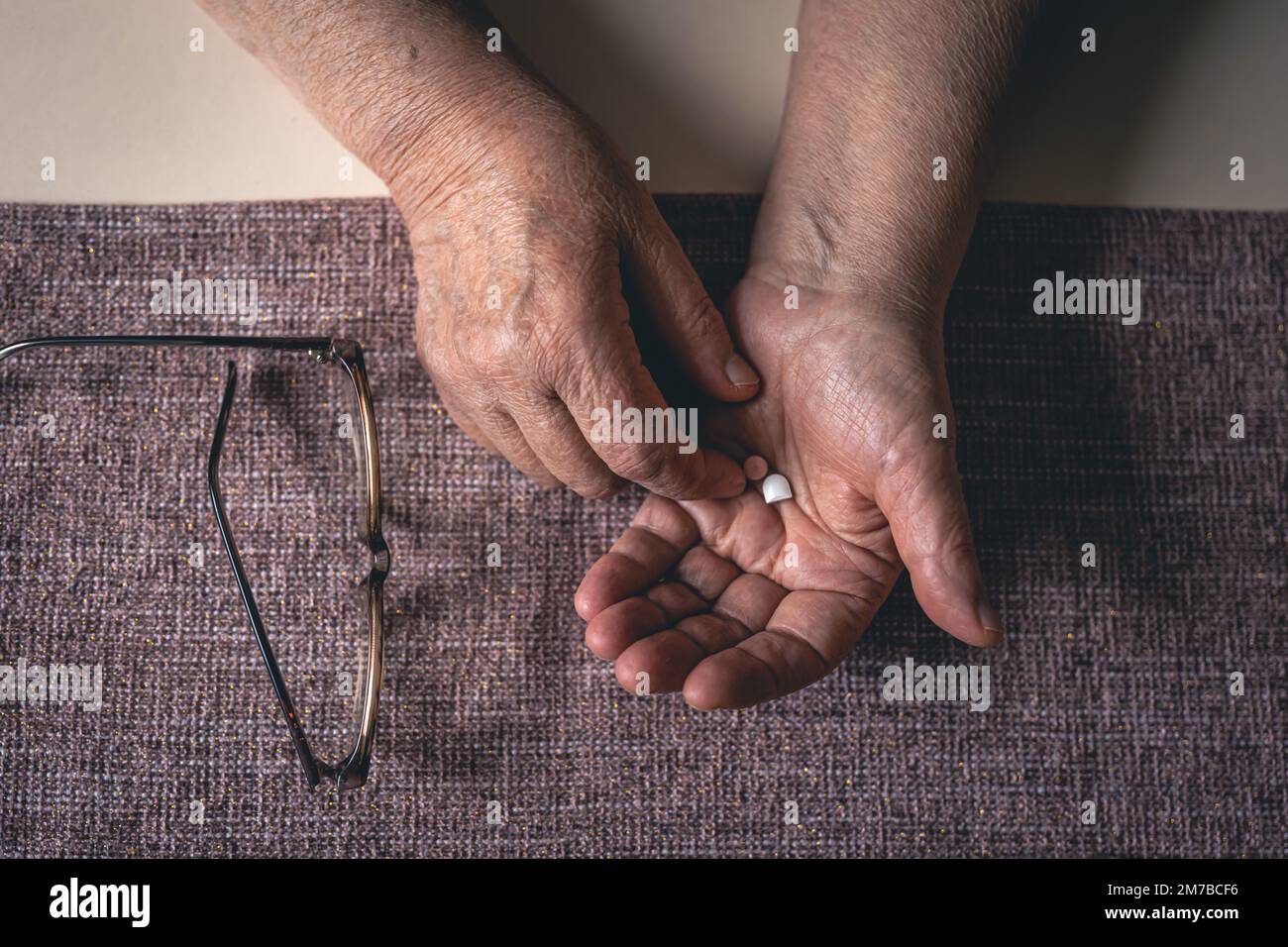 Pillen in den Händen einer alten Frau, Draufsicht. Stockfoto