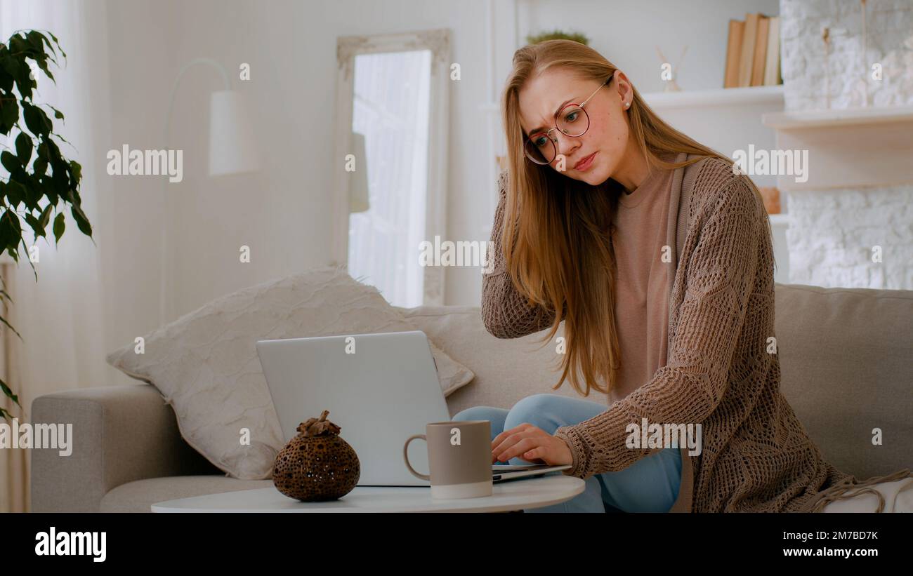 Kaukasische Frau verwirrte Mädchen mit kaputtem Laptop Sorgen sich wegen schlechter WIFI Internetverbindung ärgerliche Frau mit Brille ärgerlich wegen Online-Konto Stockfoto