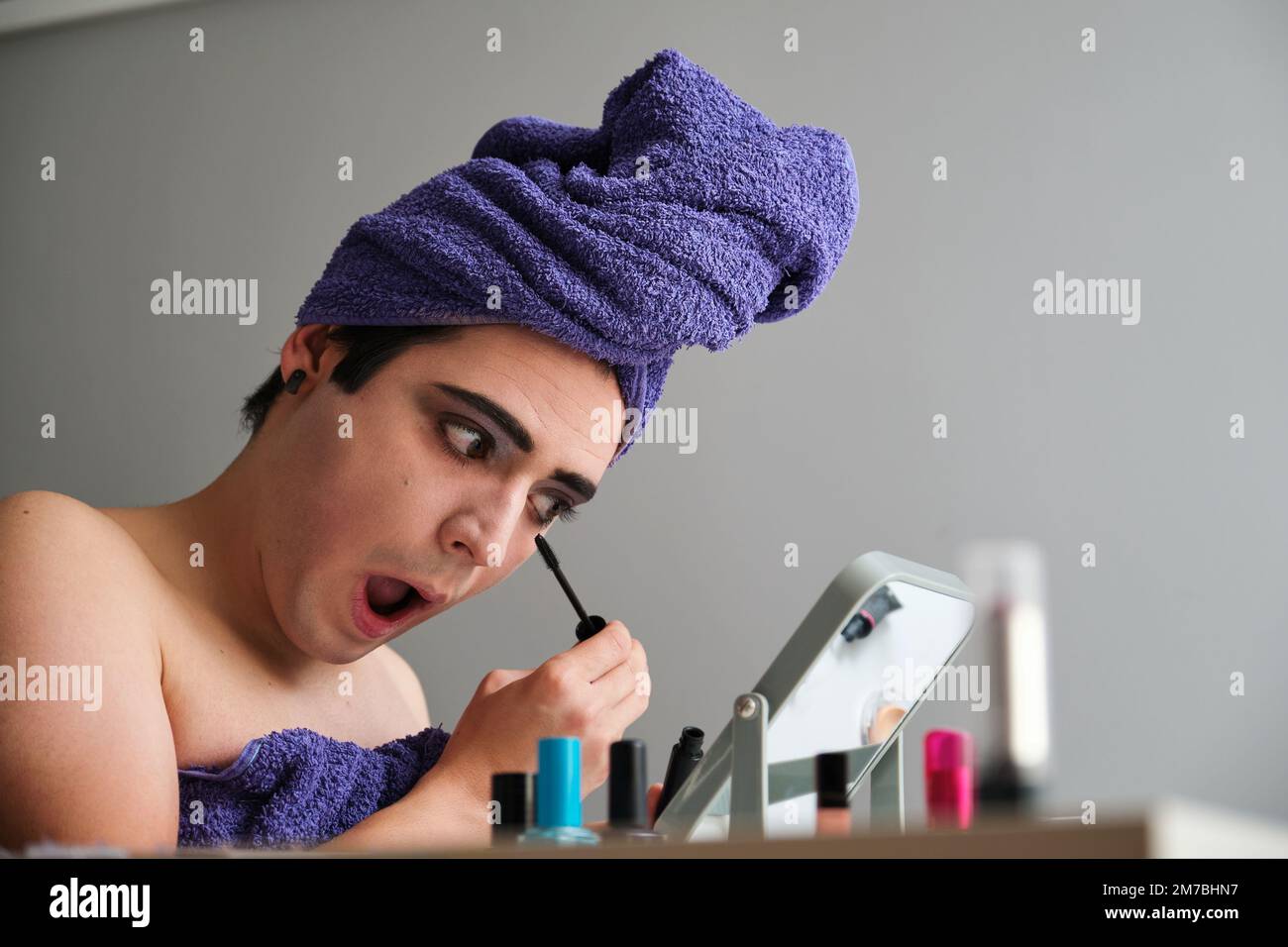 Junge Geschlecht Flüssigkeit Person Anwendung Augen Mascara. Stockfoto