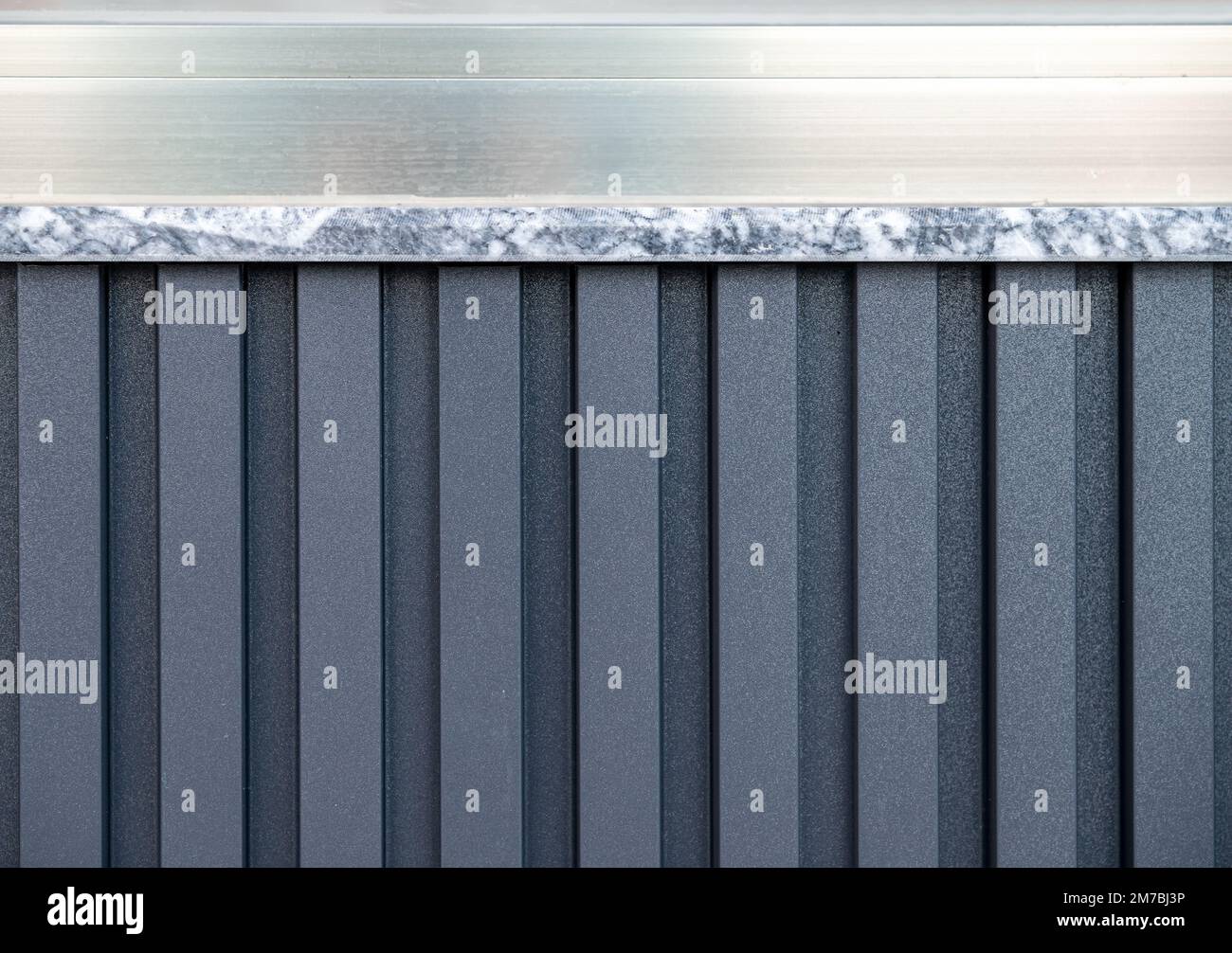 Vinylbeschichtete äußere Isolierplatte auf PVC an der Wand unter dem Aluminiumfenster Stockfoto