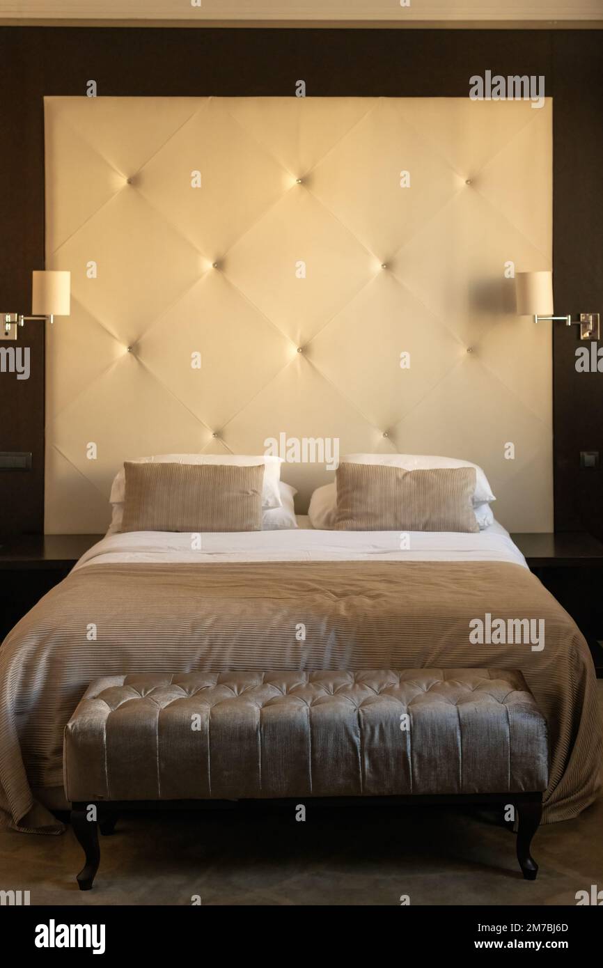 Möbel im Hotelzimmer: Ein Bett mit Kopfteil, Kissen und Nachttischlampen Stockfoto