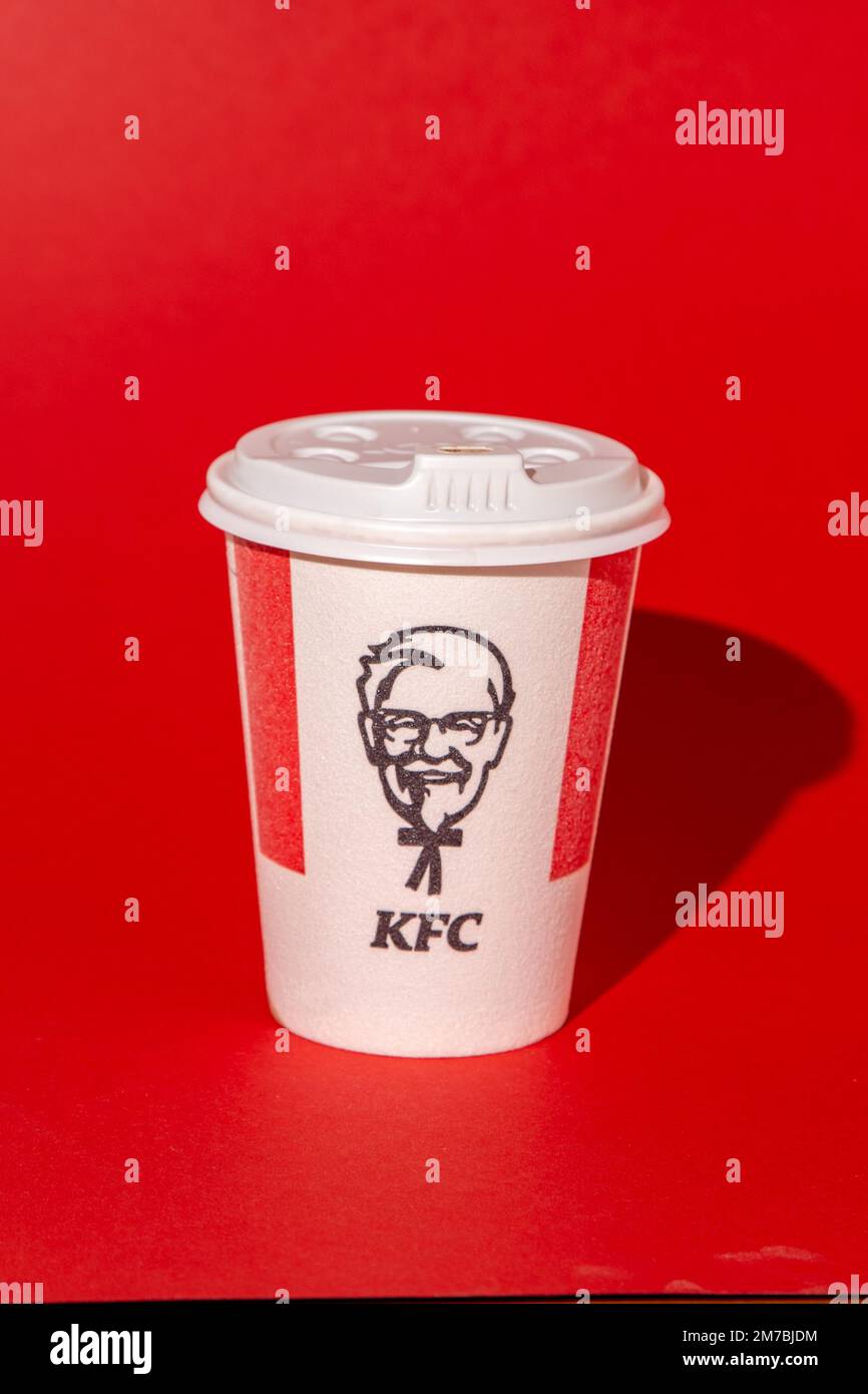 Rotes weißes KFC-Glas für Kaffee, Kakao, Tee auf rotem Hintergrund. Heißes Getränk zum Mitnehmen. Logo von Kentucky Fried Chicken. Fast-Food-Restaurant. Harland Sanders Ukraine, Kiew - 10. November 2022. Stockfoto