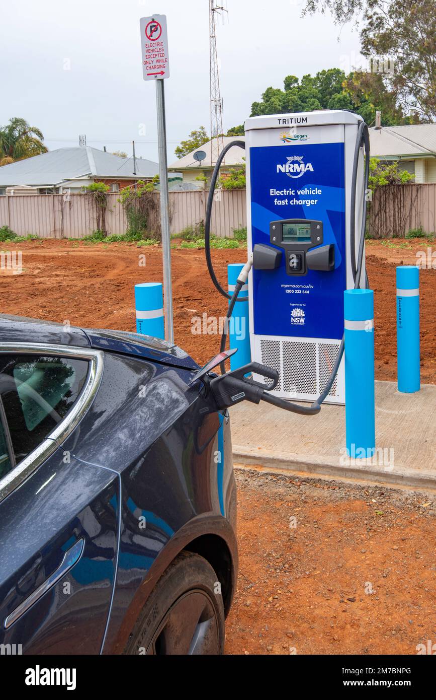 Ein Auto, das an einer Tritium NRMA-Batterieladestation für Elektrofahrzeuge (EV) auf einem Parkplatz in Nyngan im Westen von New South Wales, Australien, aufgeladen wird Stockfoto