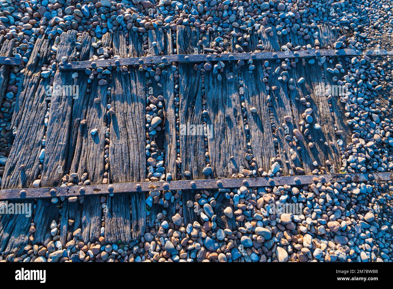 Nahaufnahme eines hölzernen Fußwegs am Kiesstrand von Rye Harbour, Großbritannien Stockfoto