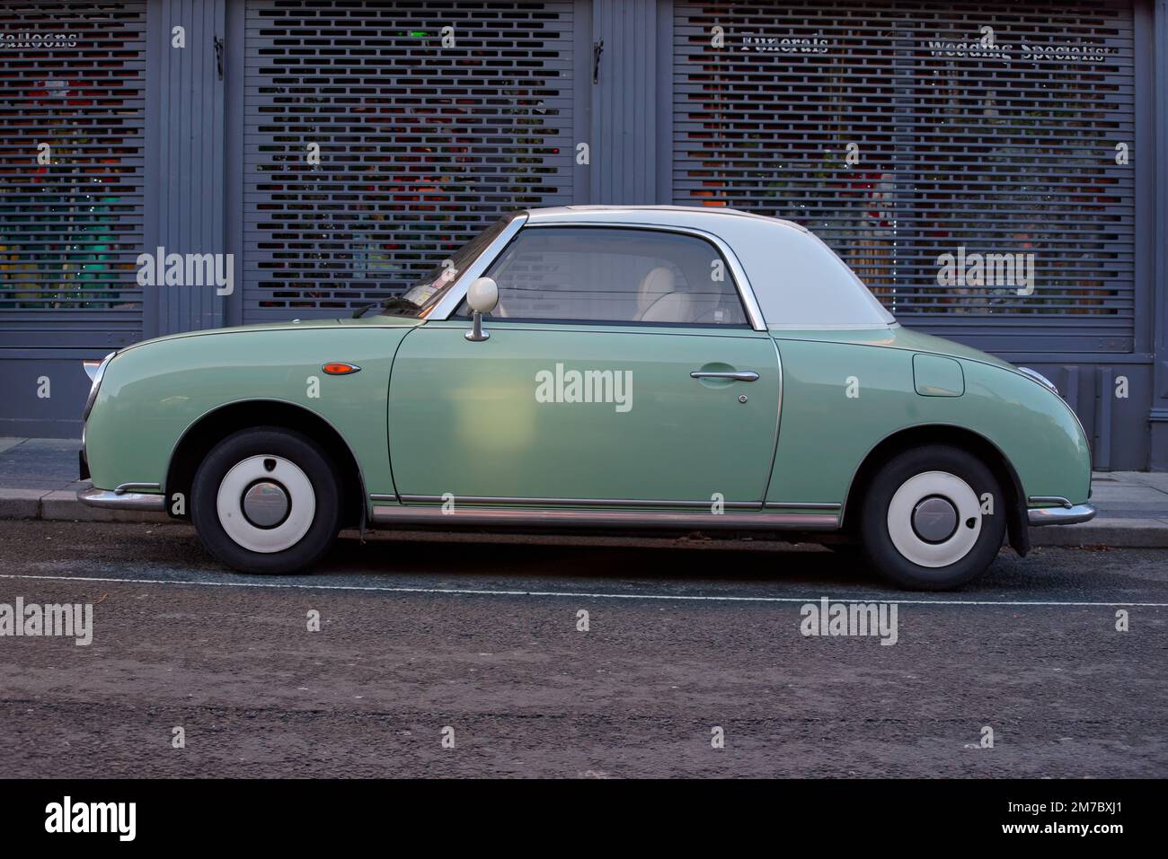 Seitenansicht des Nissan Figaro, der in einer Straße in Bray, Irland, parkt. Fahrzeug, das 1991 in Japan hergestellt wurde, mit smaragdgrüner Außenfarbe, die den Frühling symbolisiert. Stockfoto