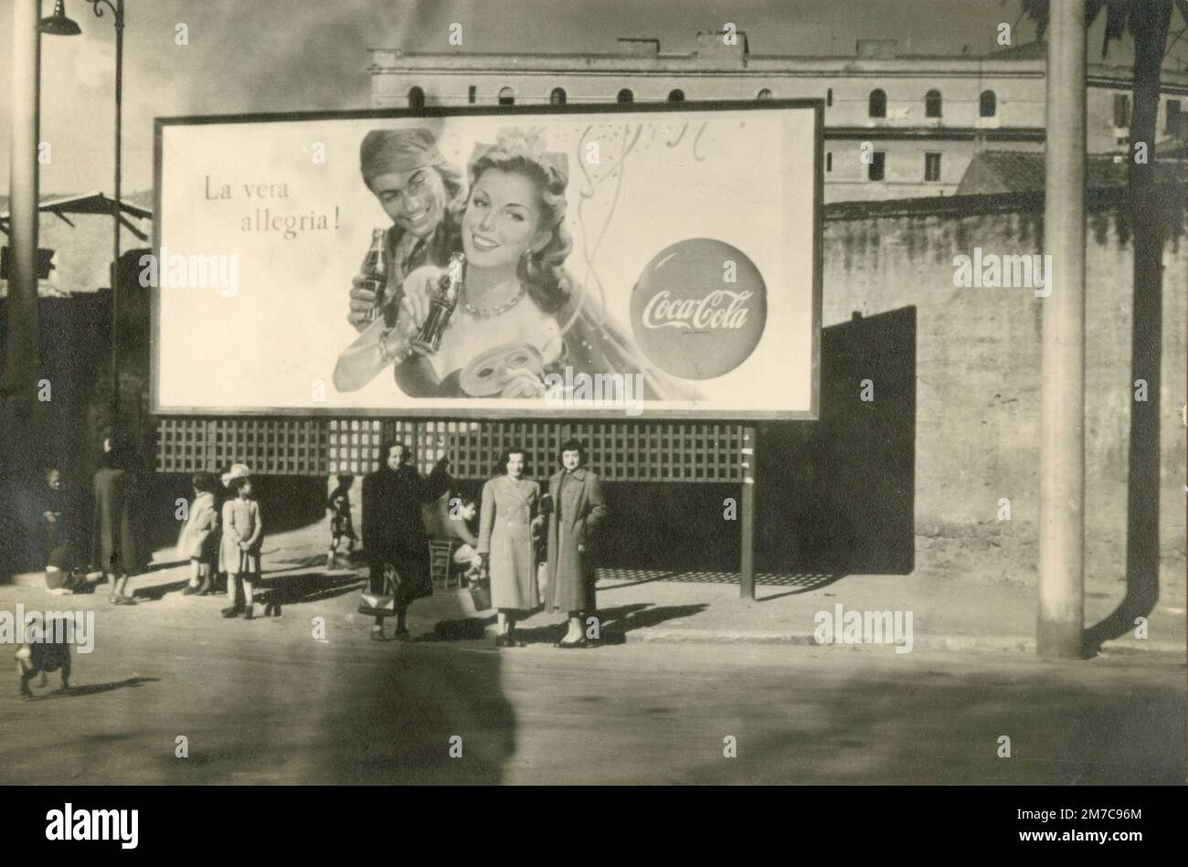 Frauen stehen auf der Straße unter einem großen Coca-Cola-Poster, Rom, Italien 1950 Stockfoto