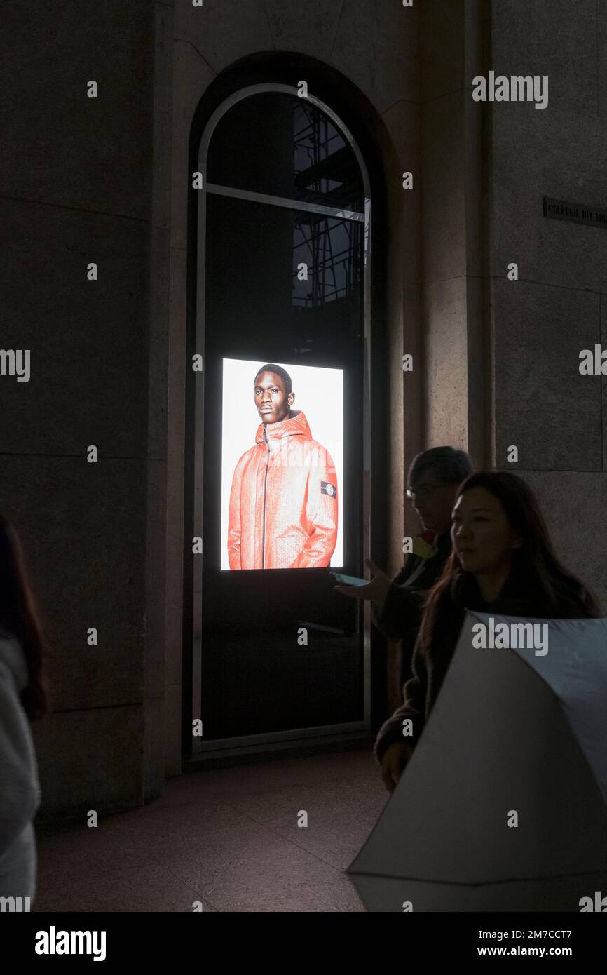 Stone Island Schaufenster mit Flagship Store in Mailand, Italien. Ein Bild mit einem farbigen Mann, der eine Jacke trägt. Wie afrikanische Modelle in der Mode eingesetzt werden Stockfoto