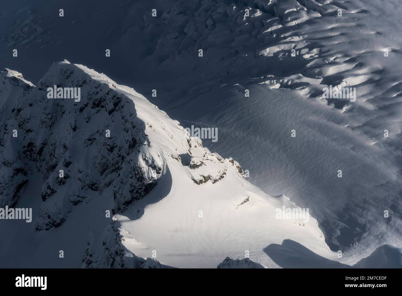 Ein Luftblick über die Eisfelder der südlichen Alpen in Neuseeland mit einem Bergkamm, interessanten Mustern und Gletscherspalten. Stockfoto