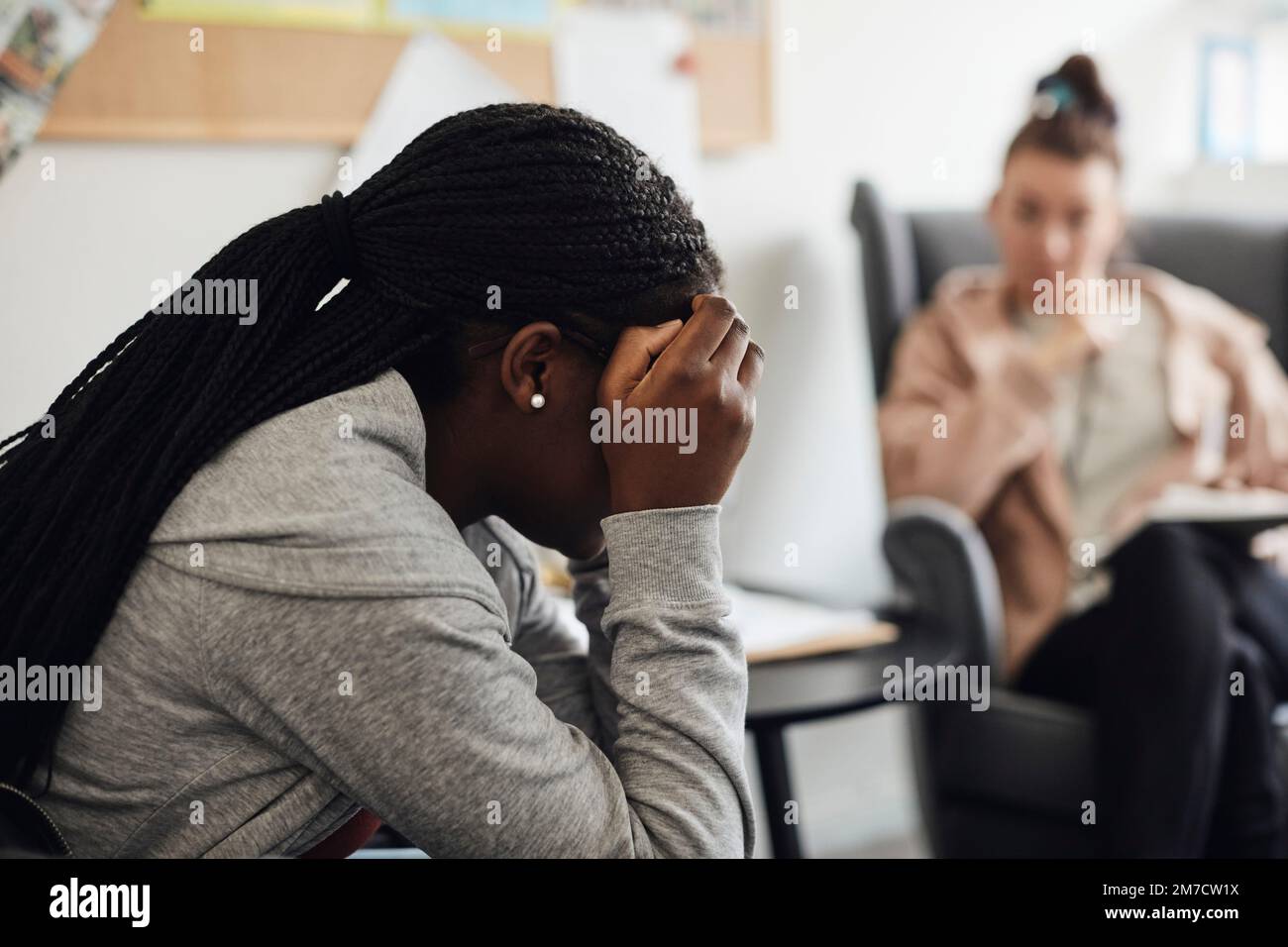 Depressive Schülerin, die mit der Betreuerin in der Schulpraxis diskutiert Stockfoto