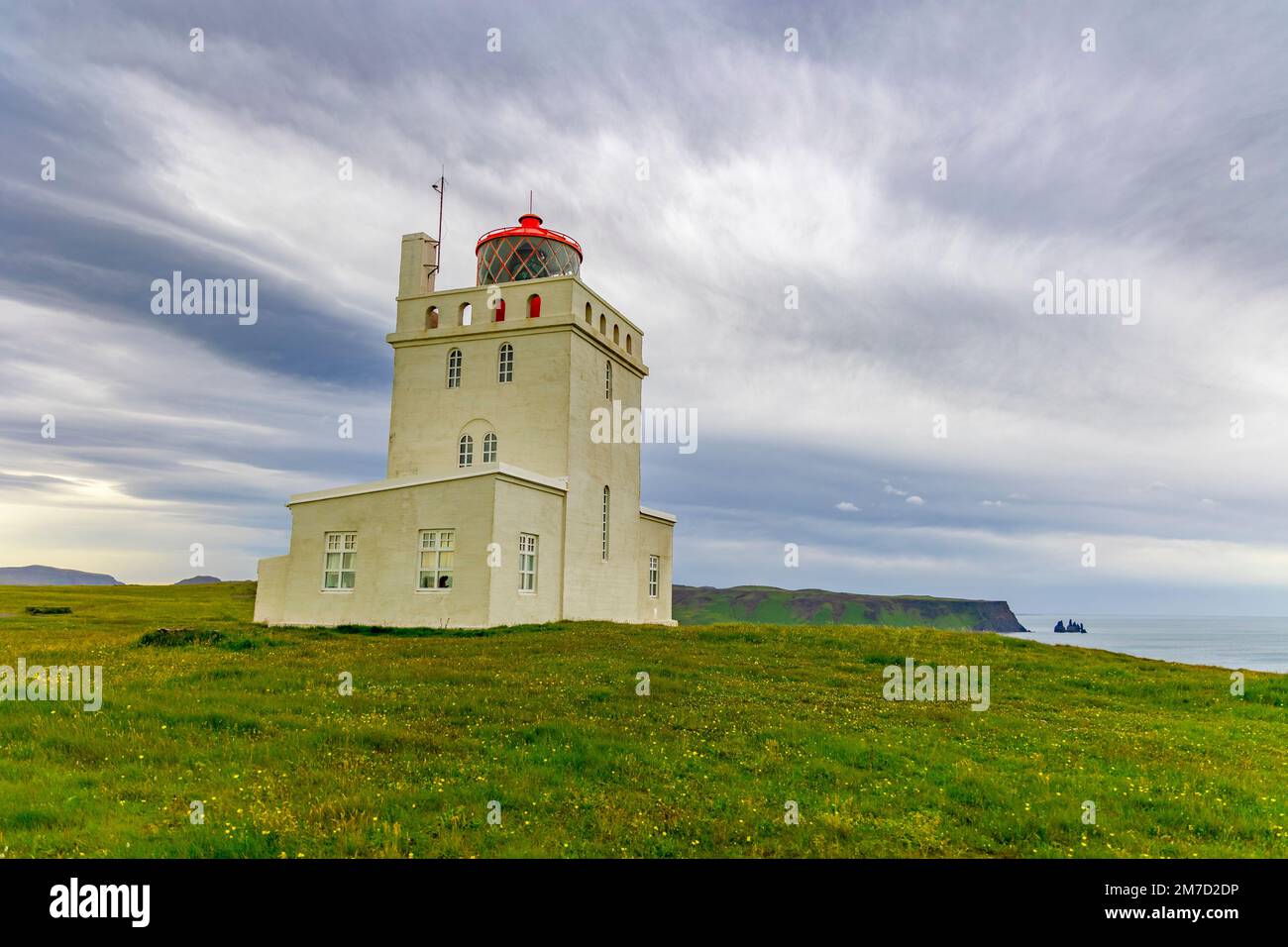 Leuchtturm und Landschaft in Dyrholaey, Island Dyrhólaey („Door Hill Island“), früher bekannt unter den Seeleuten als Cape Portland, ist eine kleine Landzunge Stockfoto