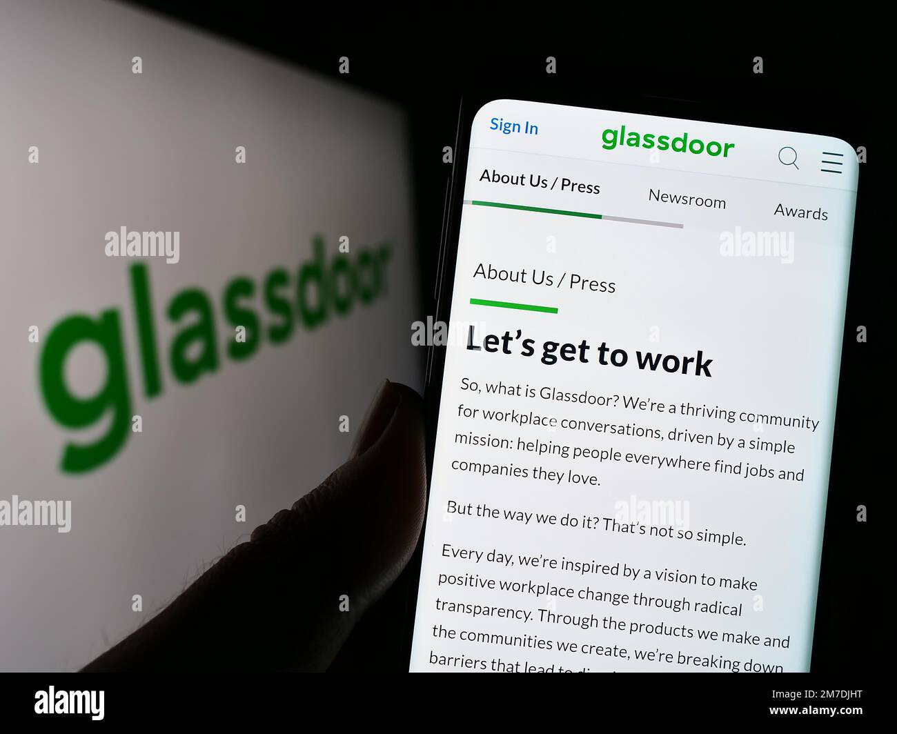 Person, die ein Mobiltelefon mit einer Webseite der US-amerikanischen Firma Glassdoor Inc. Auf dem Bildschirm vor dem Logo hält. Konzentrieren Sie sich auf die Mitte des Telefondisplays. Stockfoto