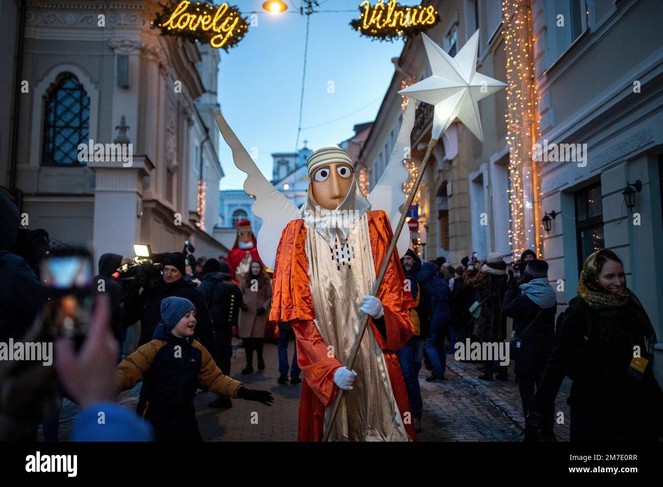 People parade through the streets as part of celebrations of Three