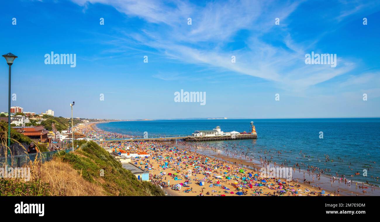 Blick auf Bournemouth Beach und Pier in Bournemouth Dorset UK bei Sonnenuntergang. Voller Strand im Sommer. Leute, die sich sonnen. Überfüllter Strand Stockfoto