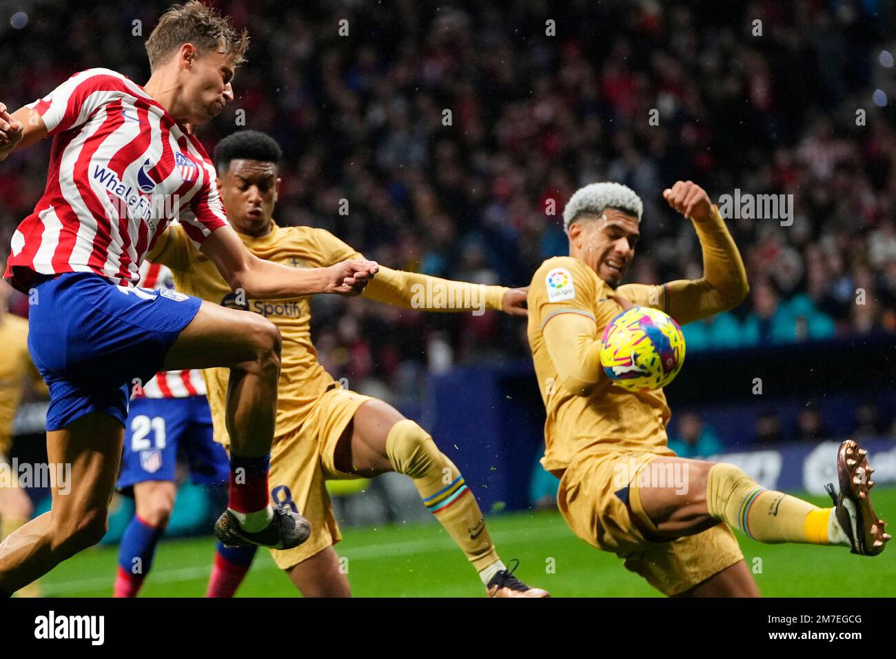 Atletico Madrid's Marcos Llorente, left, shots the ball as Barcelona's Ronald Araujo, right, tries to block during the Spanish La Liga soccer match between Atletico Madrid and FC Barcelona at Civitas Metropolitano stadium in Madrid, Spain, Sunday, Jan. 8, 2023. (AP Photo/Manu Fernandez) Stockfoto