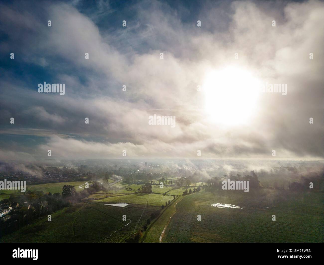 Ein nebeliger Sonnenaufgang über Cirencester in den Cotswolds, Gloucestershire. Stockfoto