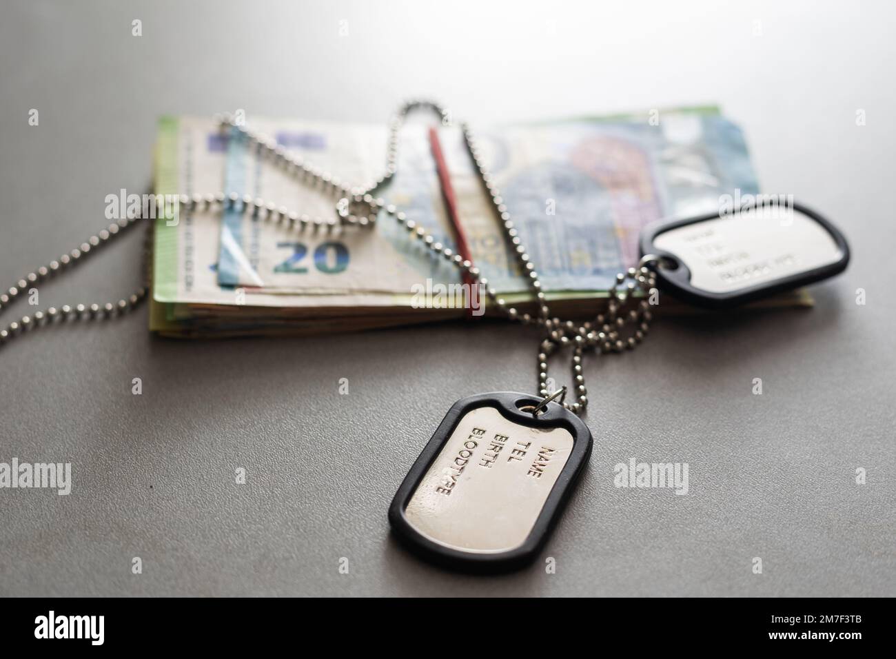 Ein Armeemedaillon ruht auf einem 100-Dollar-Schein. Konzept: Zahlung durch einen Militärsöldner, Kosten der Operation, staatliche Unterstützung, Armeerente Stockfoto