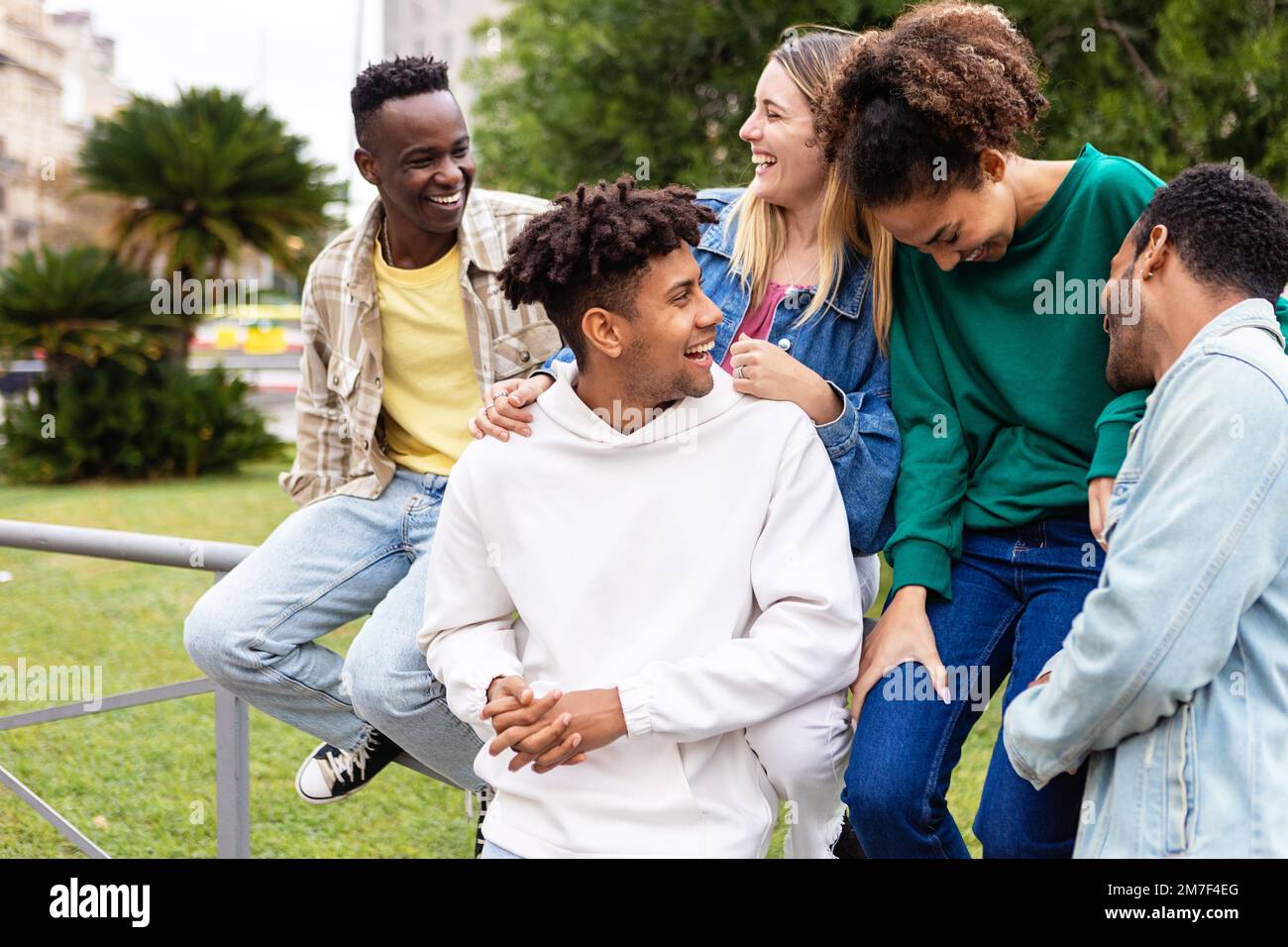 Fröhliche multiethnische Gruppe junger Freunde, die gemeinsam Spaß im Freien haben Stockfoto