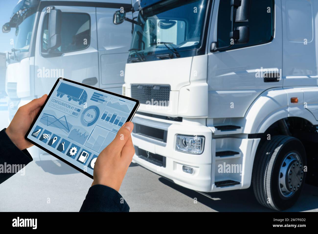 Manager mit einem digitalen Tablet neben Trucks. Flottenmanagement Stockfoto
