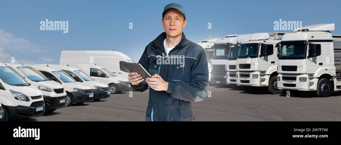 Manager mit einem digitalen Tablet neben Trucks. Flottenmanagement Stockfoto