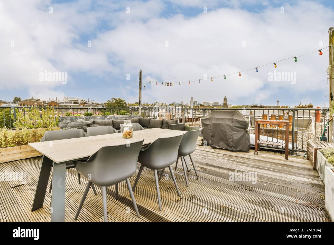 Ein Essbereich im Freien auf einer Dachterrasse mit Stühlen und Tischen im Vordergrund - Bild von oben Stockfoto