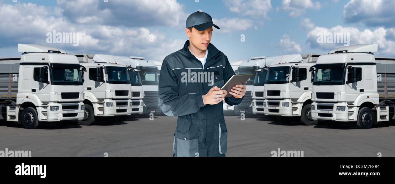 Manager mit einem digitalen Tablet neben Trucks. Flottenmanagement Stockfoto