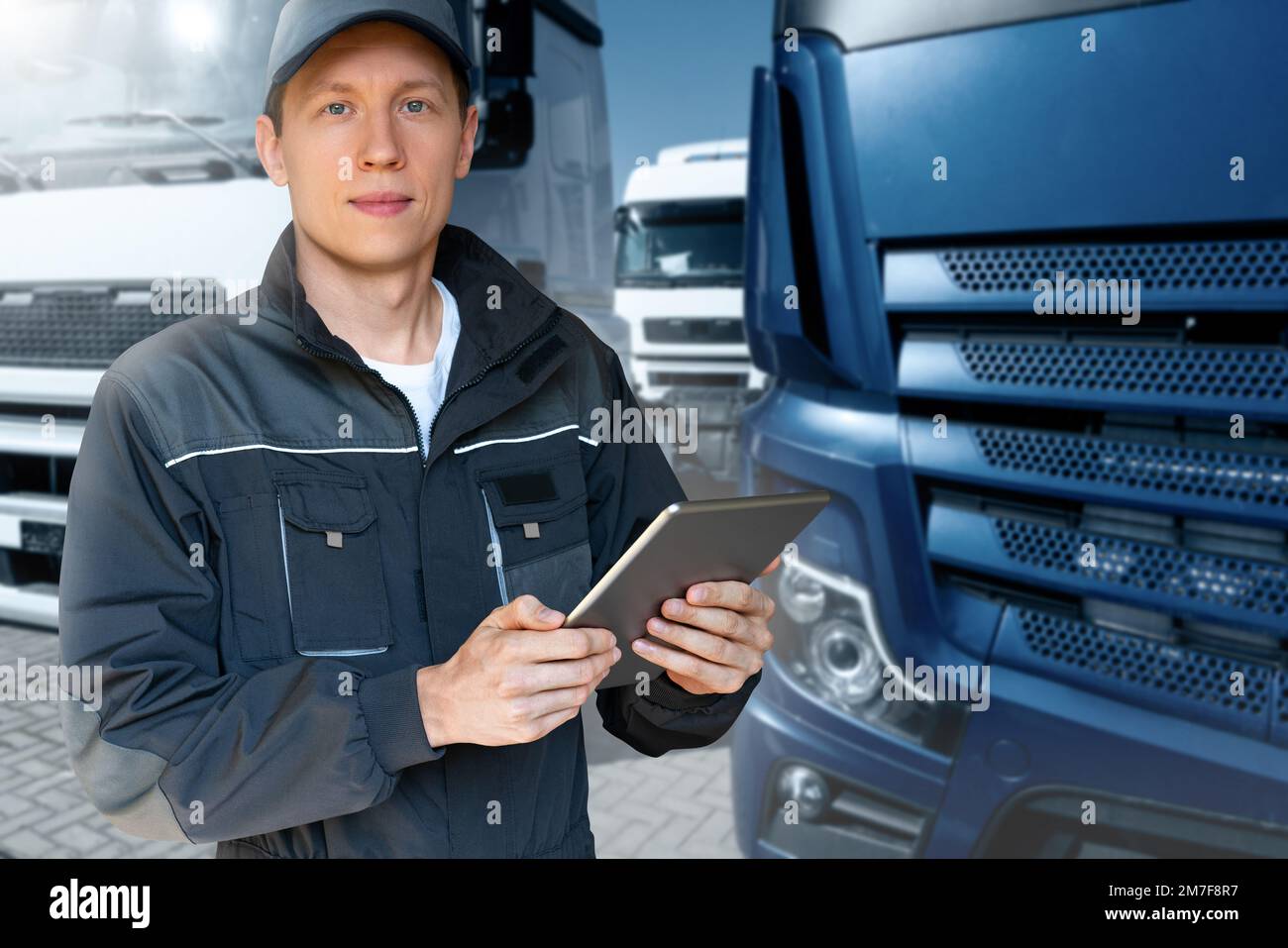 Manager mit einem digitalen Tablet neben Trucks. Flottenmanagement Stockfoto