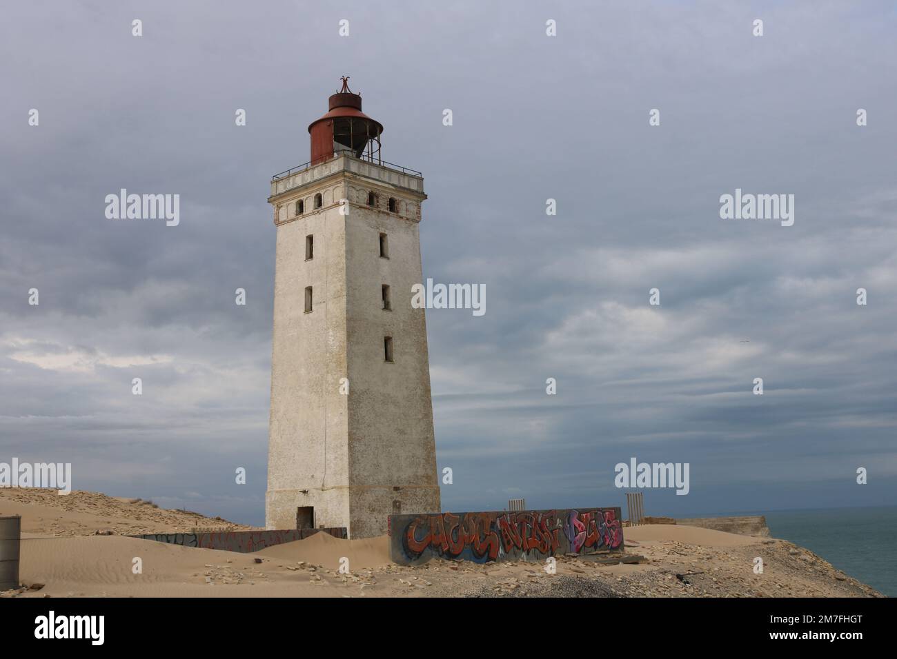 Verlassener Leuchtturm Rubjerg Knude in den Sanddünen vor einem bewölkten Himmel Stockfoto