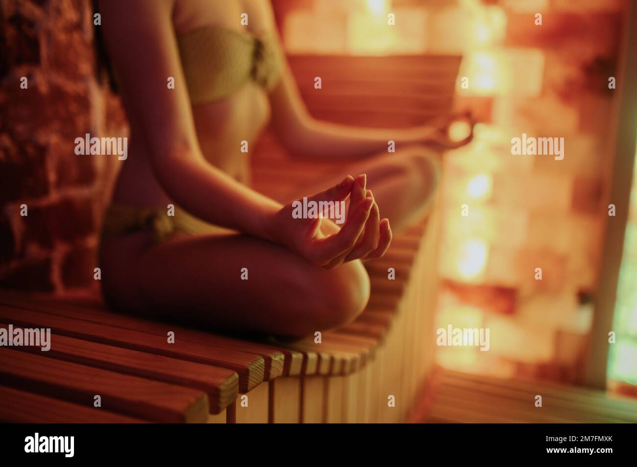 Eine Frau, die in einer Lotus-Pose sitzt und meditiert Stockfoto