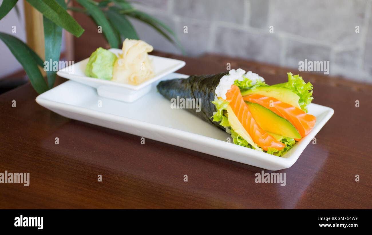 Lachs-Temaki. Temakis sind kegelförmige Sushi-Stücke aus Nori-Algen ...