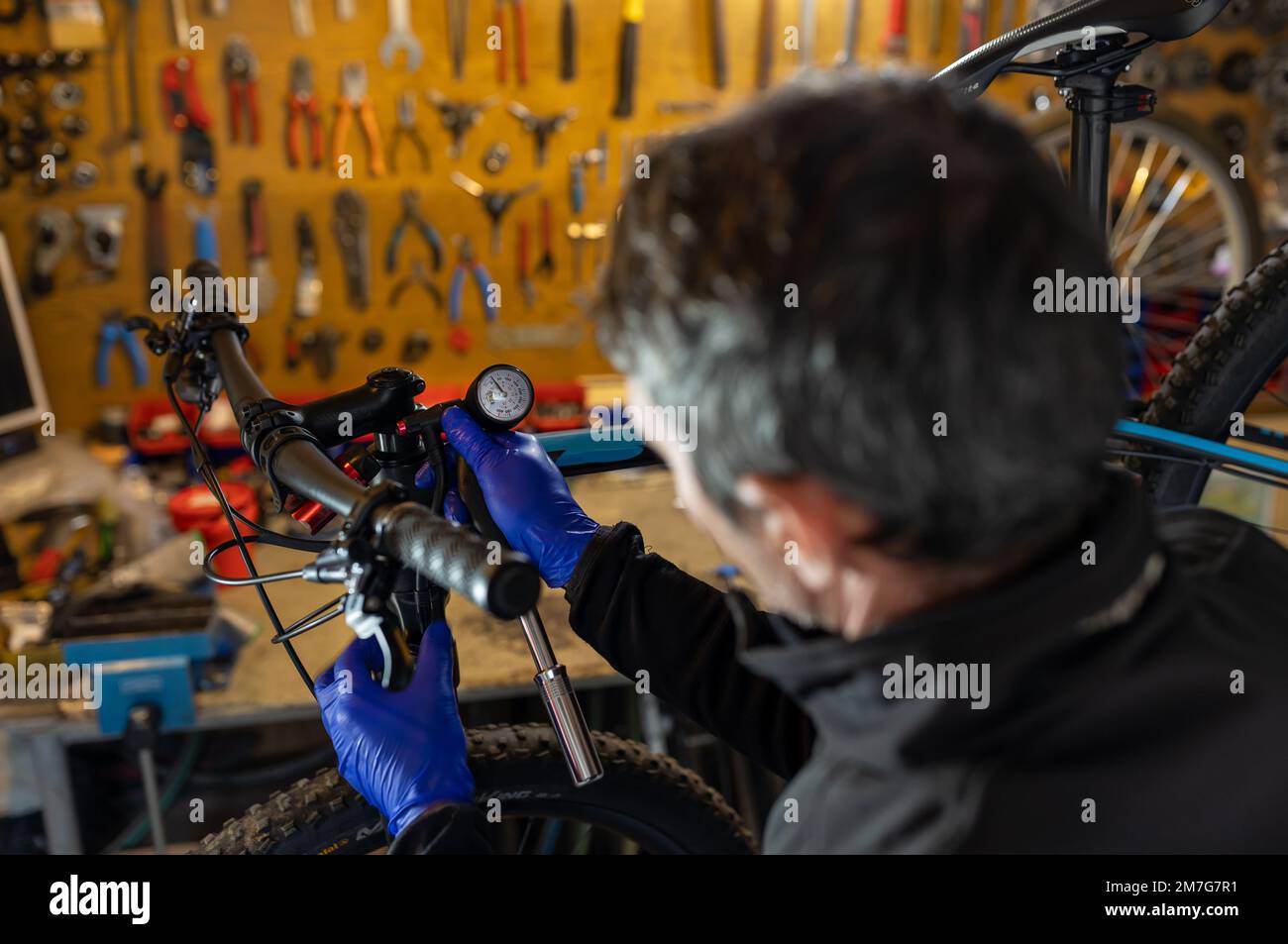 Fahrradtechniker Reparatur und Wartung von Motorrad und Stoßdämpfern in der Werkstatt Stockfoto