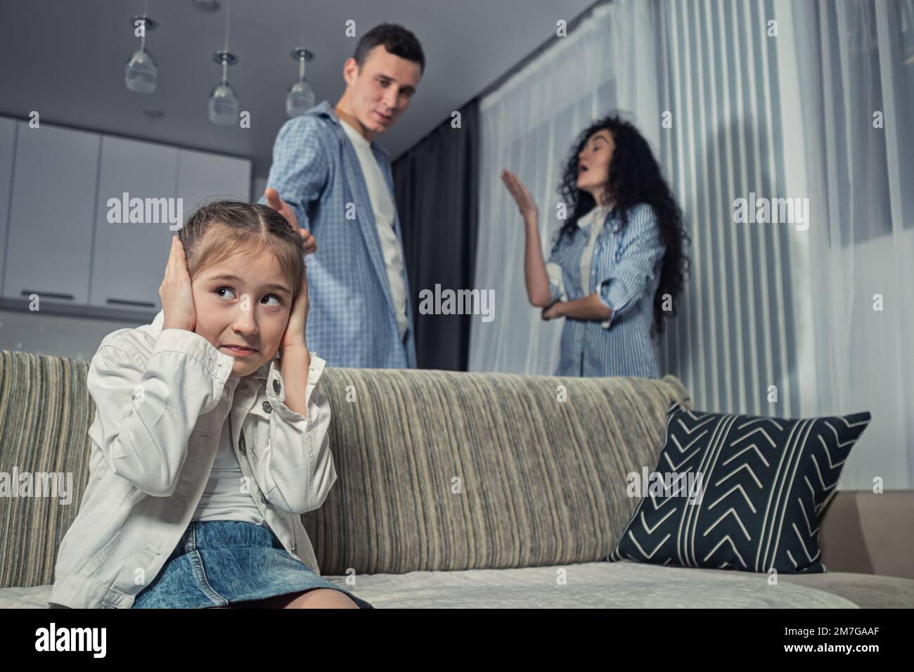Das Mädchen in der Mittelstufe hört sich gegen streitende Eltern zu Stockfoto