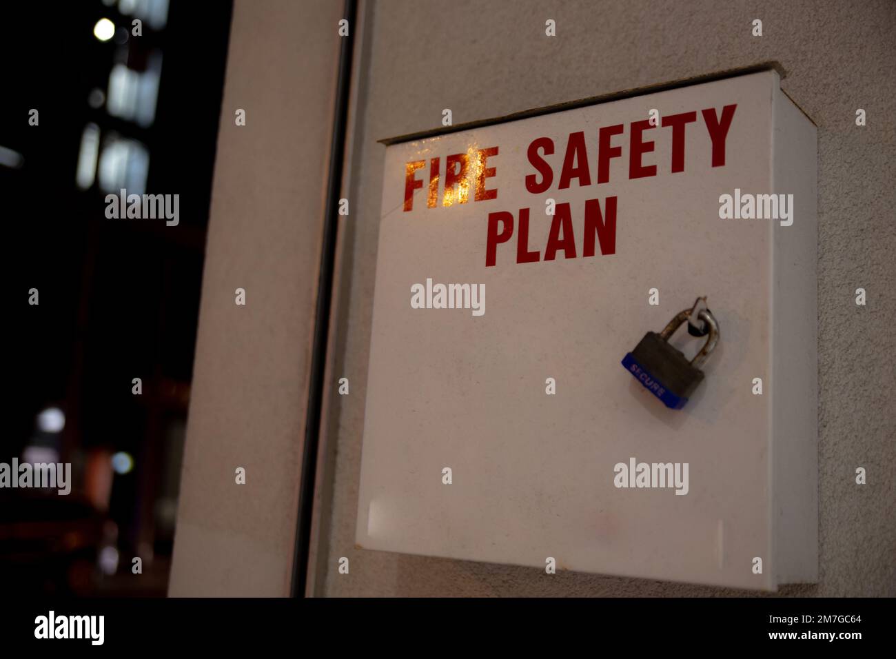 Ein Metallkasten für den Brandschutzplan neben dem Brandmelder zeigt auf die Straßen außerhalb des Gebäudes. Stockfoto