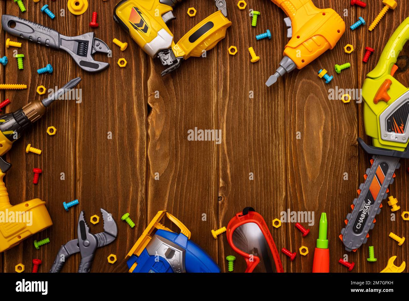 Spielzeugwerkzeuge, Bolzen und Muttern auf Holzhintergrund mit Platz für Ihren Text Stockfoto