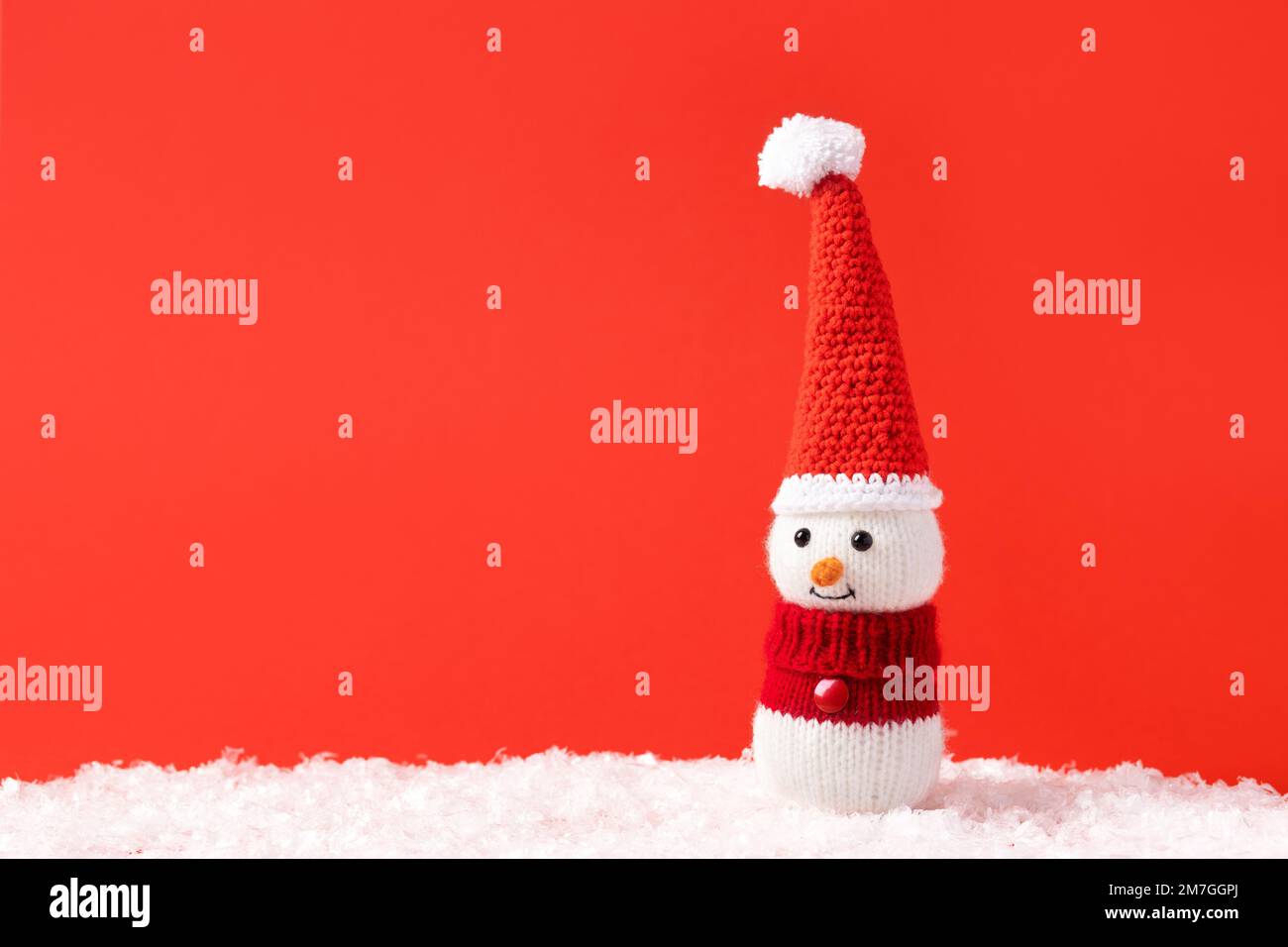 Weihnachtsmärchen-Komposition eines gestrickten Schneemanns mit Weihnachtsmann-Hut und -Pullover. Stockfoto