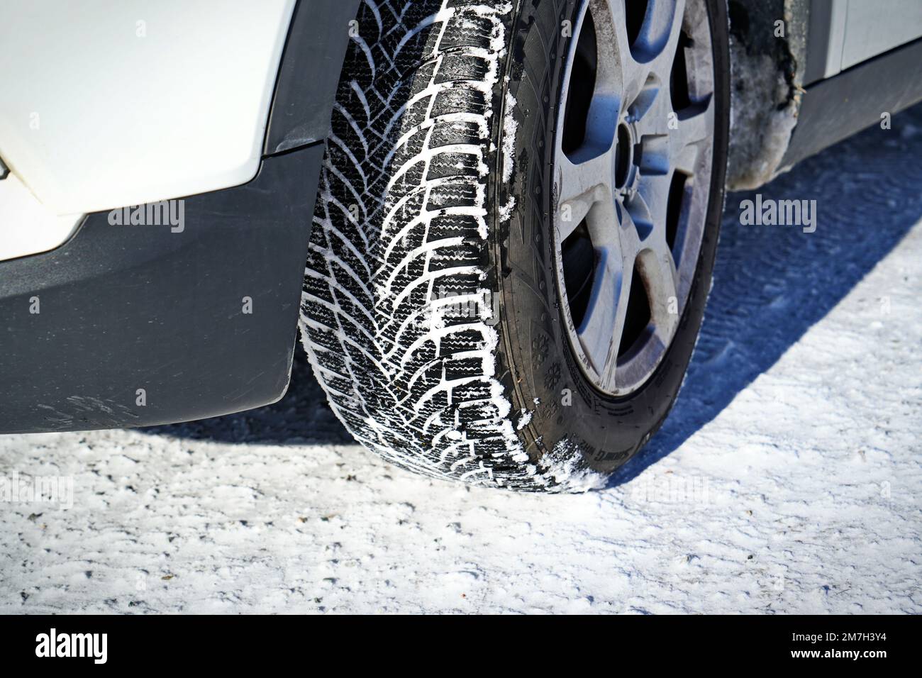 Auto mit Winterreifen auf Schneestraße fahren Stockfoto