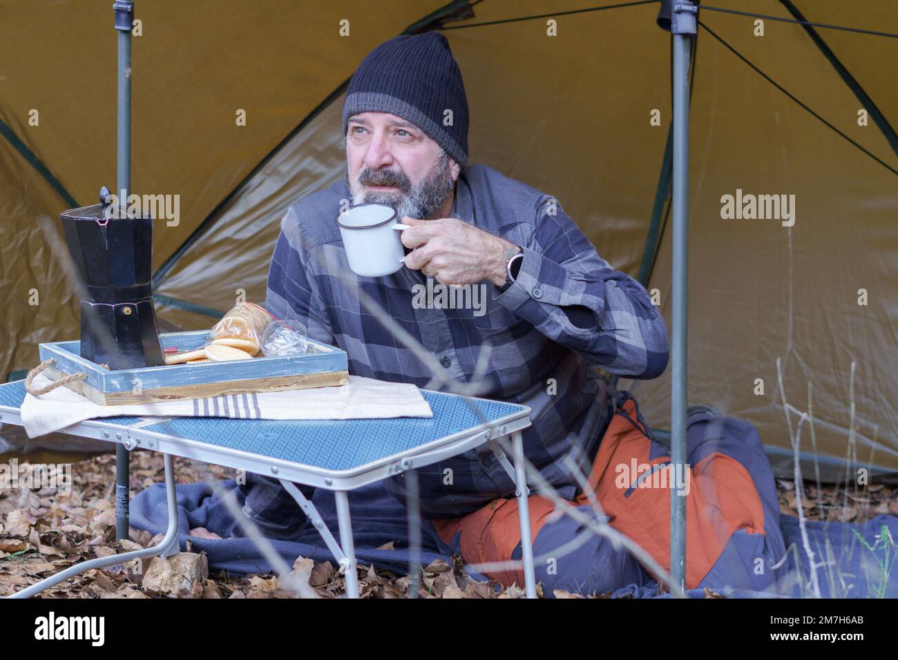 Ein Mann trinkt Kaffee in seinem Zelt Stockfoto