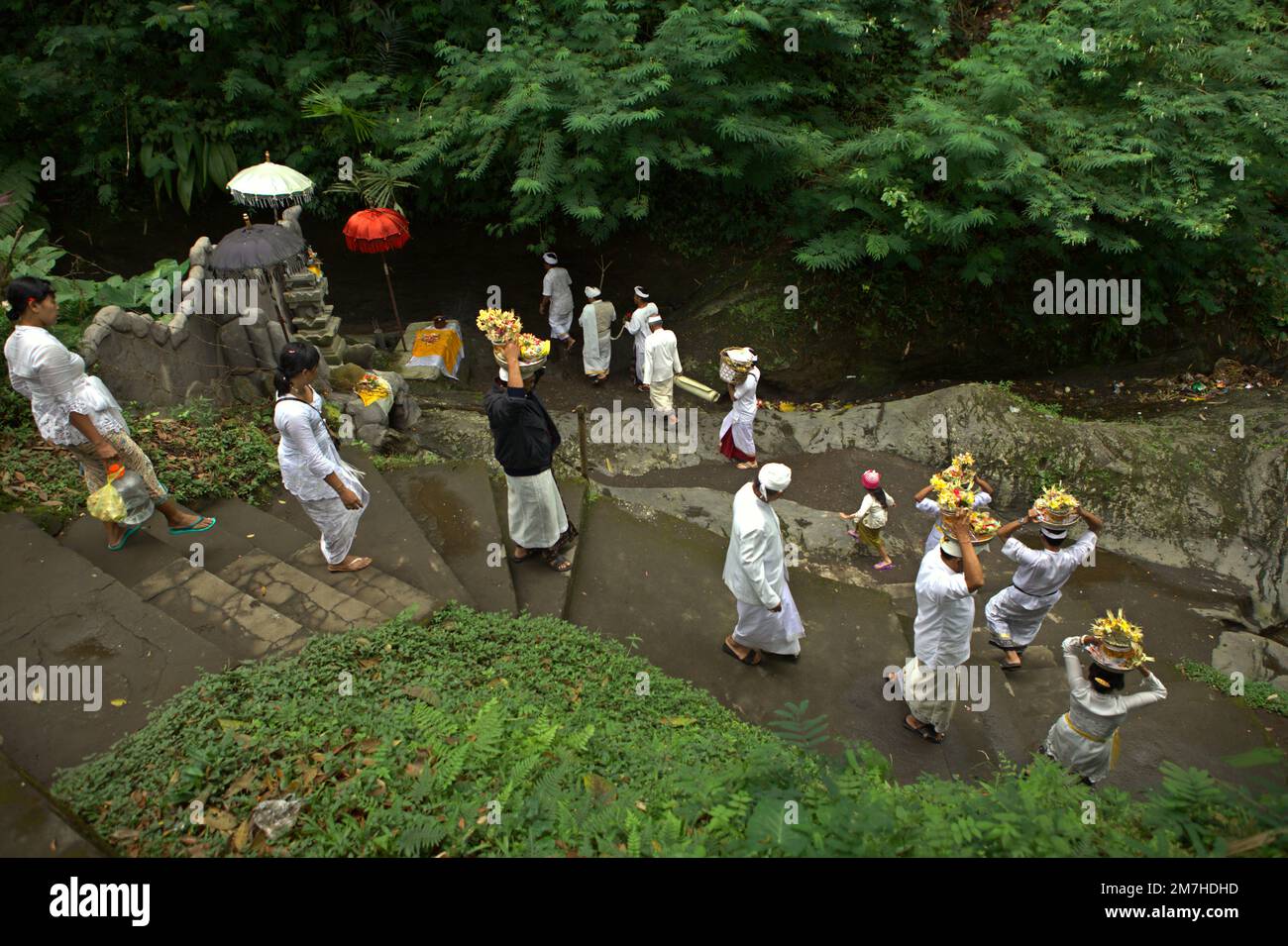 Ein balinesischer Clan läuft zusammen, während sie spirituelle Opfer während eines Rituals zur Ehre und Reinigung der Geister ihrer verstorbenen Familienmitglieder in einem Tempel in der Besakih-Tempelanlage am Hang des Agung in Karangasem, Bali, Indonesien, bringen. Stockfoto