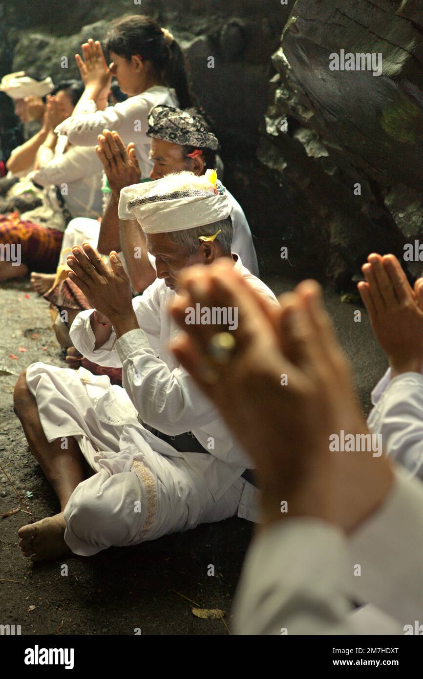 Ein balinesischer Clan betet während eines Rituals zusammen, um die Geister ihrer verstorbenen Familienmitglieder zu ehren und zu reinigen, in einem Tempel in der Besakih-Tempelanlage am Hang des Agung in Karangasem, Bali, Indonesien. Stockfoto